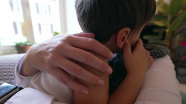 Rahatlatıcı Kucaklaşma - Evde Anne Rahatlatıcı Oğul. Sevecen Bakım Anı Çocuğun tenini ve saçlarını şefkatli ellerle okşayan