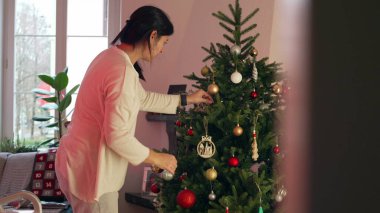 Noel ağacını Aralık ayında evde süsleyen gizli bir kadın. Otantik gerçek hayat insanı süs topları ekler, şenlikleri kutlar.
