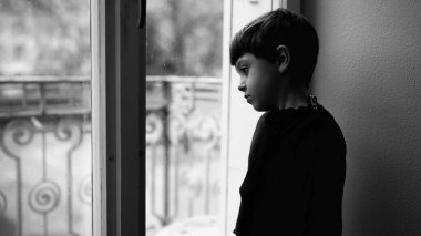 Çocukluk depresyonu, pencerenin kenarında dikilip ikinci kattaki dramatik tek renkli siyah beyaz manzaraya bakan üzgün bir çocuk tarafından resmedilmiş. Bunalımlı çocuk