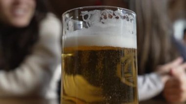 Lokantada bira fıçısını kapatıyoruz ve insanlar arka planda konuşuyor. Köpüren köpüklerle canlandırıcı alkollü içecek