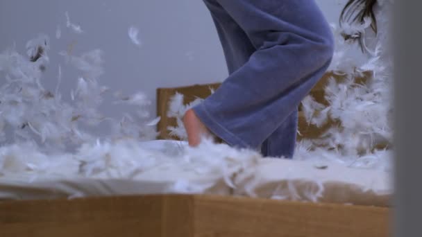Nogi Dziecka Stojące Łóżku Pokryte Piórami Latającymi Powietrzu Bardzo Zwolnionym — Wideo stockowe