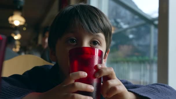 Kleiner Junge Träumt Tagträumend Restaurant Roten Plastikbecher Gelehnt Und Starrt — Stockvideo