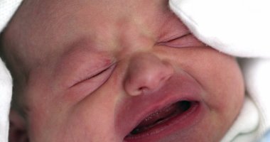 Close-up of newborn baby infant crying, first day of life