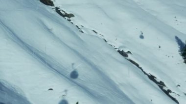 Kayak sezonunda kayak sezonunda yüksek dağların tepesinden görülen çok sayıda kayak gölgesi - yolcu POV 'tan görülüyor