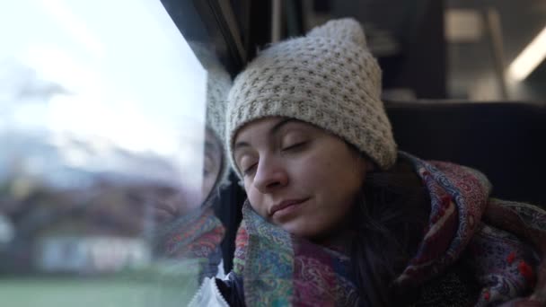 女人在乘火车旅行时睡着了 女性乘客靠在车窗上行走时闭上眼睛 — 图库视频影像