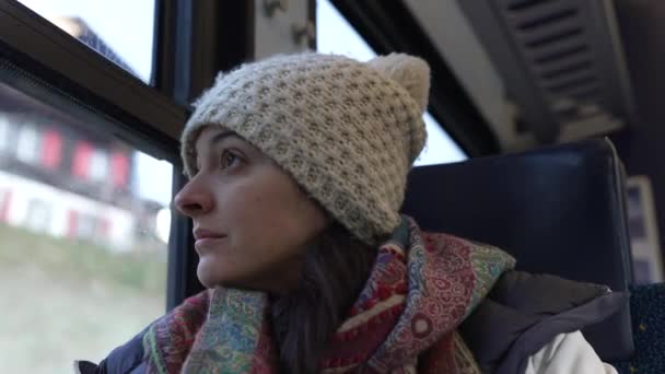 沉思的女人穿着冬衣 心事重重 坐火车从座位上走过 凝视着窗外的风景 — 图库视频影像