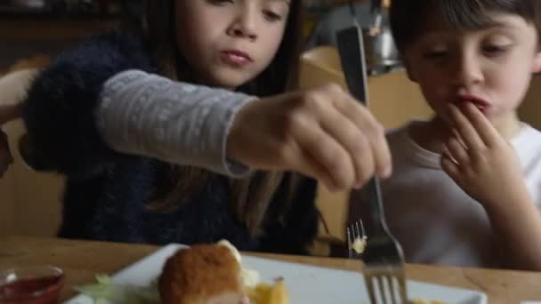 孩子们在餐馆里吃薯条 兄弟姐妹们在餐馆里吃午饭 家庭周末活动 兄妹午膳时间 — 图库视频影像