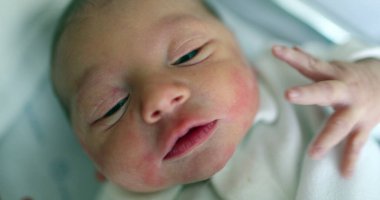 Cute newborn baby first day of life crying, observing world