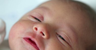 Newborn baby close-up face crying, first day of life