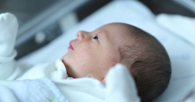 Baby newborn infant inside hospital crib after birth