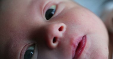 Baby newborn infant in first week of life, closeup of portrait face