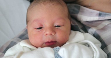 Baby newborn with mom layed in hospital bed