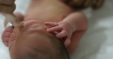 Calming newborn baby by suckling finger feeding