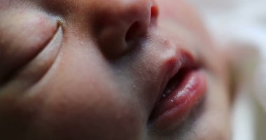 Newborn baby face portrait in macro. Close-up of infant in first day of life