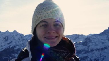 Alp Zarafeti - 30 'lu yaşlardaki kadın portresi Arka planda karla kaplı dağlar, İsviçre manzarasının ortasında kışın giyinmiş