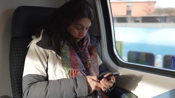 Dojeżdżająca Kobieta Spogląda Urządzenie Komórkowe Pociągu Siedzącym Przez Okno Widokiem — Wideo stockowe