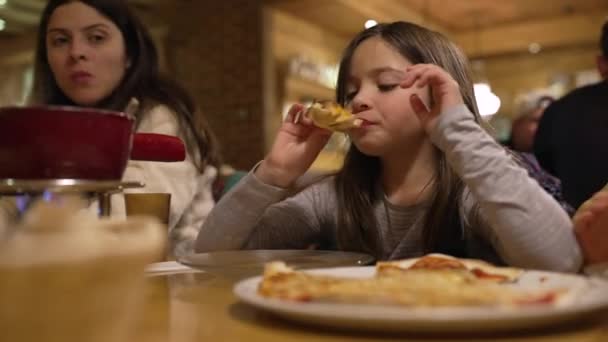 小女孩在餐馆吃比萨饼 家人在周末的晚餐活动中一起享受时光 — 图库视频影像