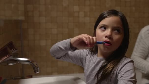 Anne Küçük Kardeşin Diş Fırçalamasına Yardım Ederken Kız Banyo Aynasının — Stok video