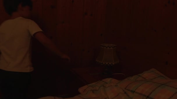 孩子们打开传统木制小木屋内部的床头灯 一个小男孩打开了传统的古灯 — 图库视频影像