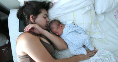 Bebek ve anne yatakta yatıyor.