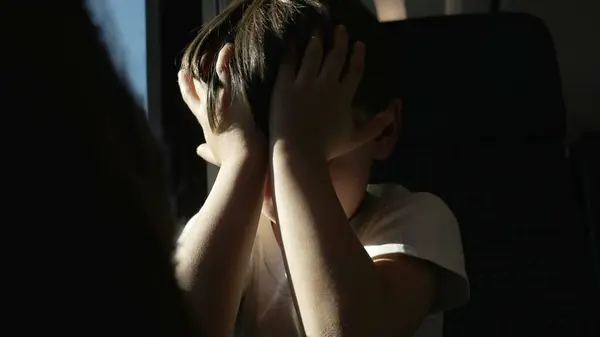 Exhausted Child Rubbing Eyes on Moving Train, Waking from Nap by window while traveling, protecting himself from sun rays
