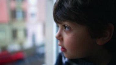Profilde, küçük çocuğun evinden pencereye baktığı görülüyor. Çocuk dışarı bakıyor, evde kapalı.