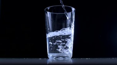 Yavaş Taze Su Hareketi Siyah Arkaplanda Cam Kupa 'ya dökülüyor