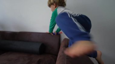 Oğlunun annesiyle oynadığı sabah oyunu. Üç yaşında bir çocuk Kanepede Yastık Kalesine dalıyor, anne oyuncak tabancayla oynuyor, ailesi oyuna dalmış.