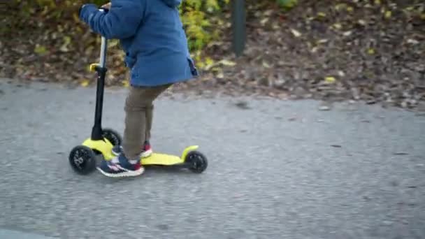 Closeup Child Feet Riding Three Wheeled Scooter — Stock Video