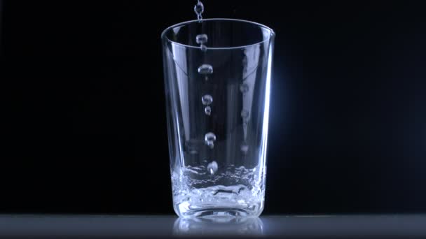 Water Glazen Beker Gieten Super Slow Motion Een Zwarte Achtergrond — Stockvideo