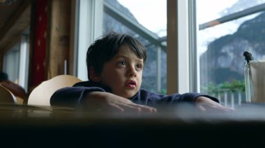 Restorandaki sıkılmış çocuk menüden hangi yemeği seçeceğini bilemiyor. Lokantadaki küçük çocuğun otantik tepkisi yorgun hissetmesi.