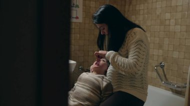 Dürüst anne yatmadan önce banyoda çocuğun ayaklarını fırçalıyor. Akşam rutininde diş bakımı.