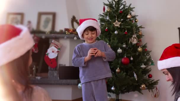 Szczęśliwy Mały Chłopiec Świętujący Boże Narodzenie Czerwonym Kapeluszu Otwierający Prezent — Wideo stockowe