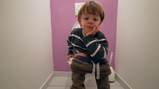 Tuvalette Oturan Düşünceli Çocuk Yaşında Bir Çocuk Tuvalette Ihtiyaçlarını Gideriyor — Stok video