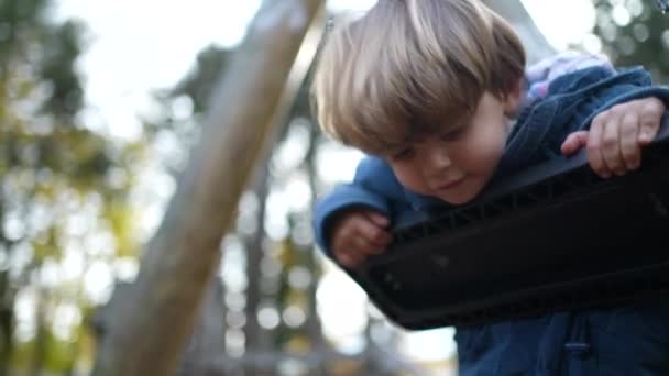 Hravý Malý Chlapec Kroucení Otáčení Při Opírání Park Swing Během — Stock video