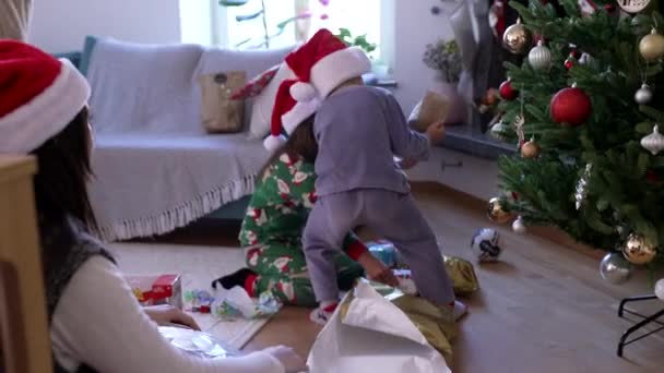 Kinderen Openen Kerstcadeautjes Ochtend Familie Viert Traditie Met Rode Hoeden — Stockvideo