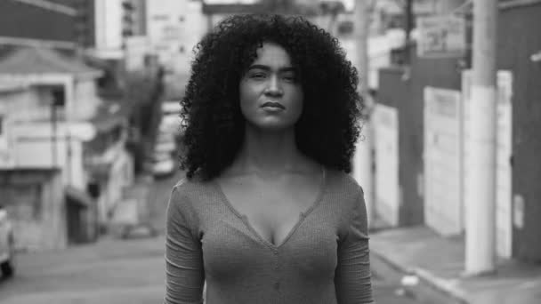 一位非洲裔美国青年妇女站在街上凝视着镜头 黑白相间 城市环境中一名20多岁的黑人成年女孩的近视镜头追踪 — 图库视频影像
