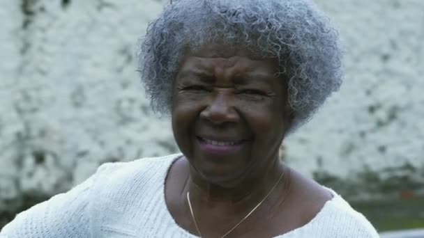 一名快乐的巴西黑人老年女士与灰白头发微笑在相机 户外街道场景跟踪拍摄特写脸 — 图库视频影像
