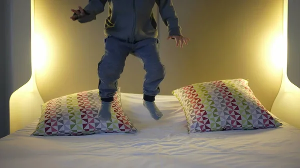 Joyful Child Jumping on Hotel Bed - Vacation Fun. Little boy bouncing up and down