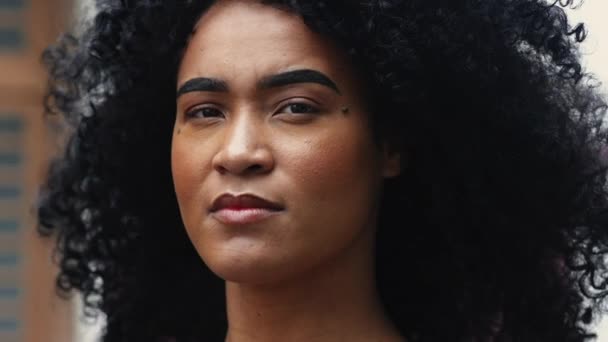 ストリートにポーズするカーリーヘアを持つ1人の若い黒人女性の肖像画 — ストック動画