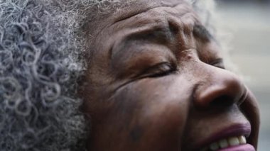 Minnettar kıdemli Afrikalı Amerikalı kadın makro-yakın çekim gözleri ve FAITH ve UMUT ile gökyüzüne dik dik bakan yüz. Meditasyon PRAYER 'da gözleri kapatıp açmak