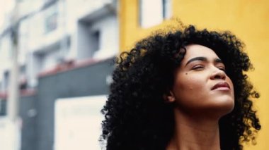 Yüksek Gücün Varlığını Hisseden Afrikalı Amerikalı Kadın 'a inanan Skyward Close-Up Face' e şehir ortamında ilham kaynağı oldu. Umudu olan düşünceli genç bir siyahi kadın.