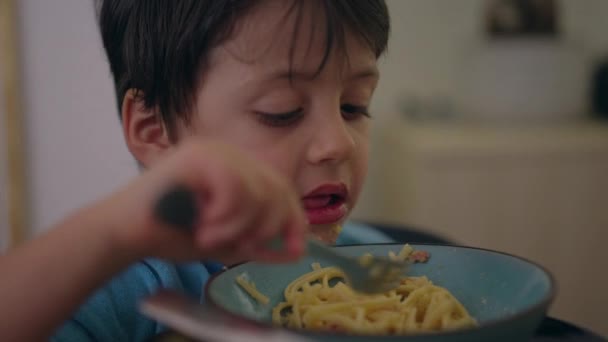一个小男孩一个人吃饭的时候吃意大利面 用叉子吃面食的孩子 — 图库视频影像