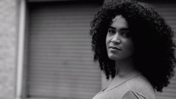 在城市环境中赋予非洲裔美国妇女权力 用黑白分明 单色的黑白照片追踪自信年轻女性面孔的特写 一个黑人站在街上凝视着摄像机 — 图库视频影像