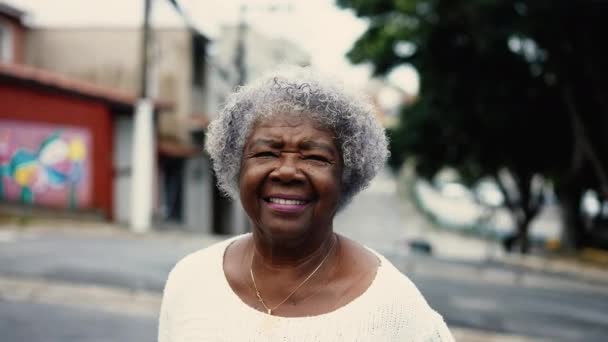 一个成熟的黑人老年妇女走在外面的城市街道上 80多岁的非洲裔美国老太太在城市里散步 看着相机 — 图库视频影像