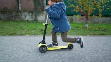 Aktif Üç Yaşındaki Çocuk Üç Tekerli Scooter 'la gezintiden keyif alıyor.