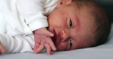 Baby newborn waking up after nap opening eyes and observing the world