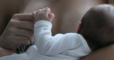 Baby little hand holding mother finger, first day of life