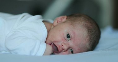 Adorable newborn baby infant smiling feeling happy discovering the world