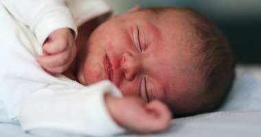 Baby newborn waking up from nap stretching body